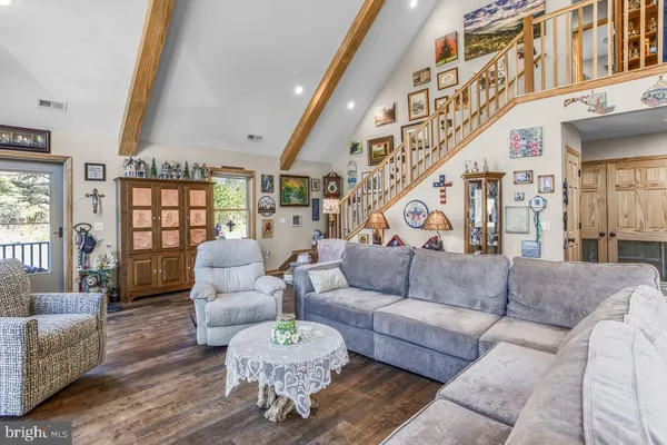 a living room with furniture a large window and wooden floor