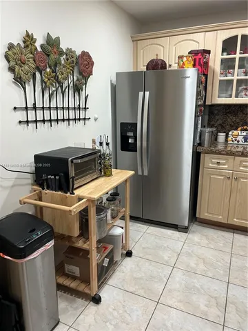 a kitchen with stainless steel appliances granite countertop a refrigerator and a stove