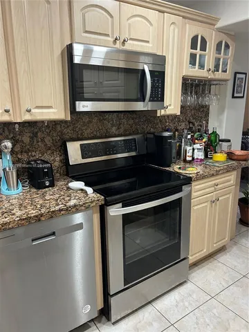 a kitchen with stainless steel appliances granite countertop a refrigerator and a stove top oven