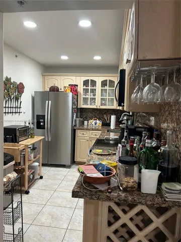 a kitchen with stainless steel appliances granite countertop a refrigerator and a sink