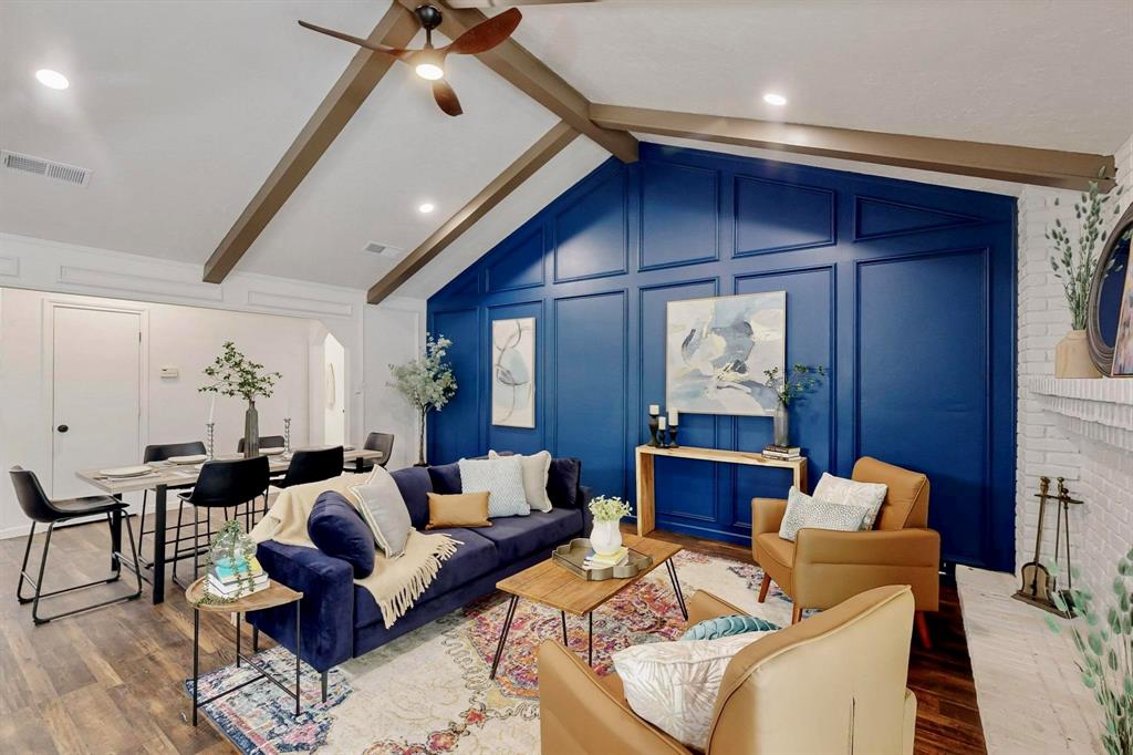 3965 Singleleaf Lane Fort Worth, TX 76133 - Photo 11 of 39 Vaulted ceiling with exposed wood beams, accent wall with panel molding, wood-finish flooring, white painted brick fireplace, and recessed lighting
