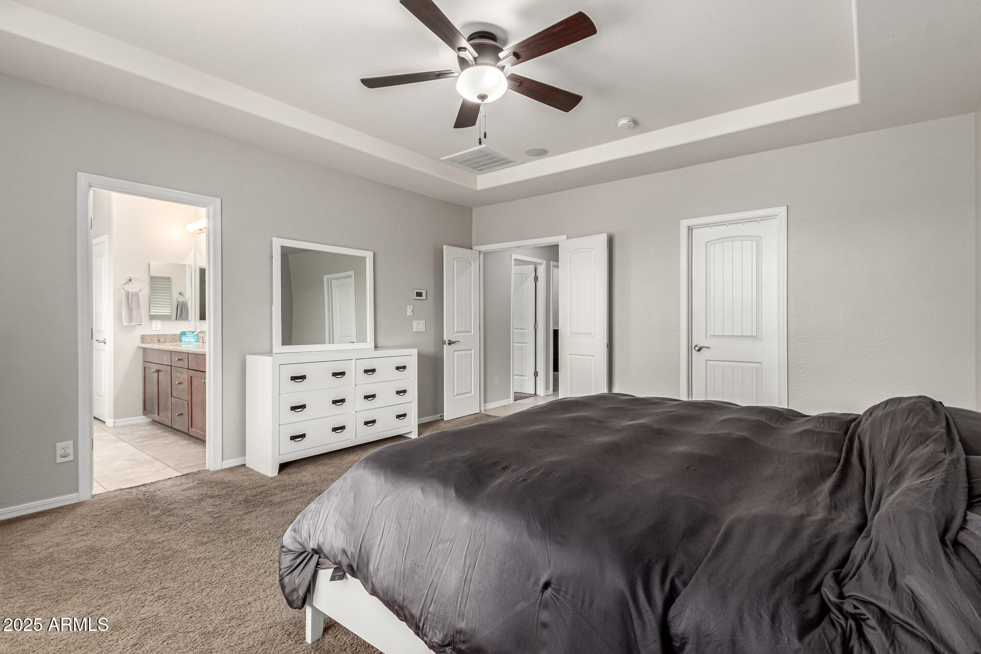 3135 East Ridgewood Lane Gilbert, AZ 85298 - Photo 14 of 39 a spacious bedroom with a bed a dresser and a chandelier