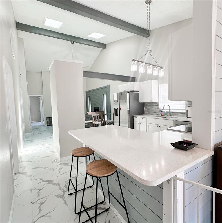 3208 Timberline Road Winter Haven, FL 33880 - Photo 2 of 21 a kitchen with stainless steel appliances a table and chairs in it