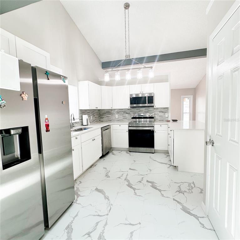 3208 Timberline Road Winter Haven, FL 33880 - Photo 6 of 21 a kitchen with stainless steel appliances granite countertop a stove a refrigerator and a sink