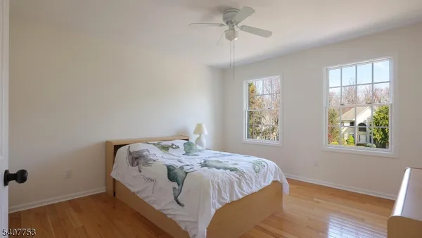 a view of an empty room with wooden floor and cabinets