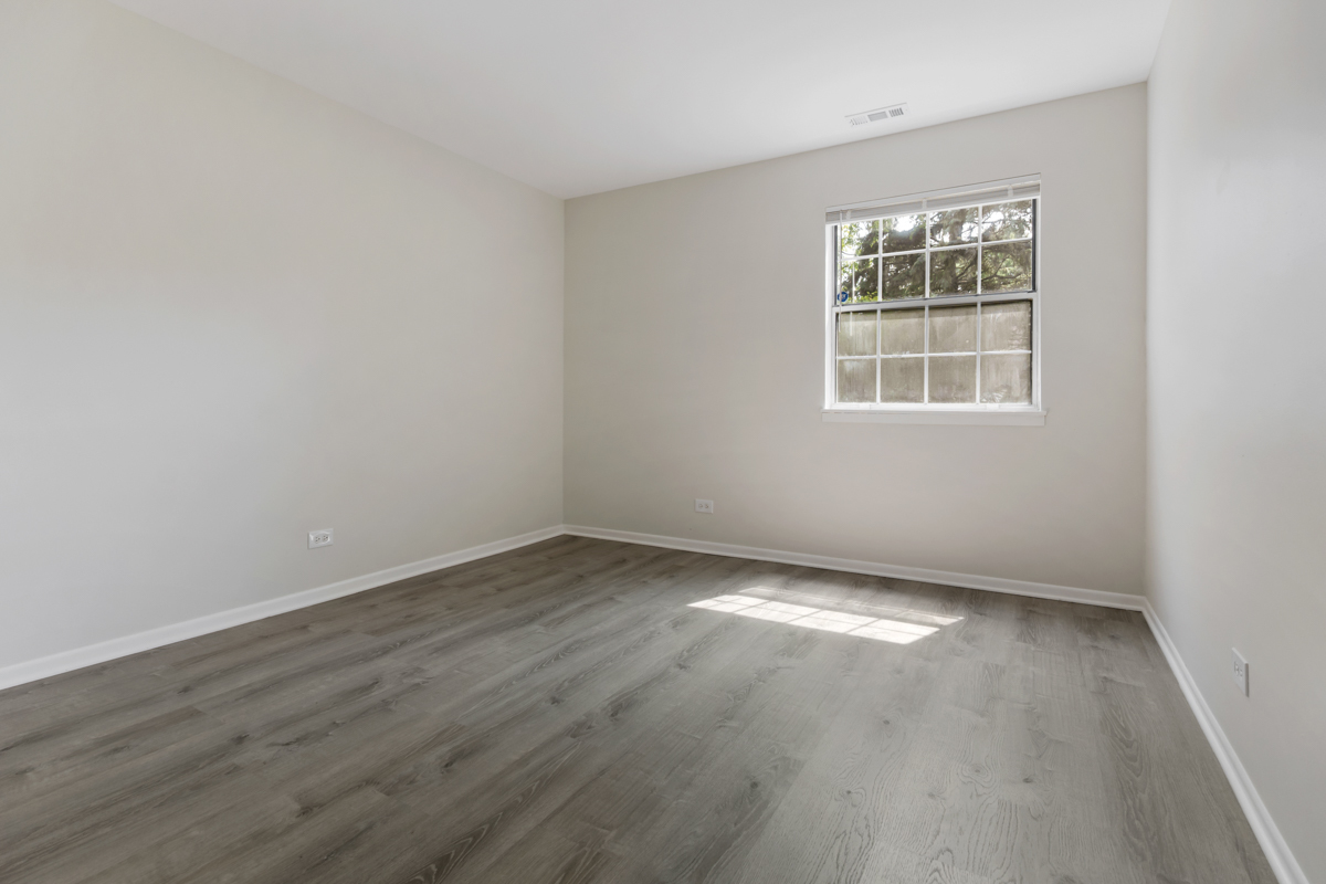 8 Gant Circle, Unit A Streamwood, IL 60107 - Photo 11 of 20 an empty room with wooden floor and windows