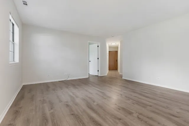 a view of an empty room with wooden floor