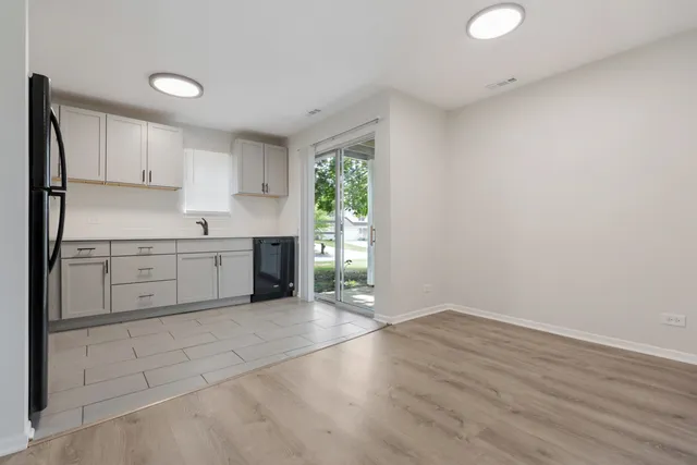 a view of a kitchen with wooden floor and a window