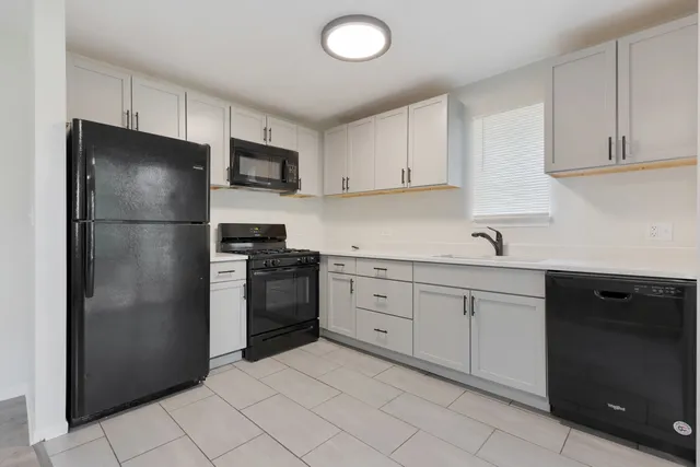 a kitchen with a refrigerator sink and cabinets