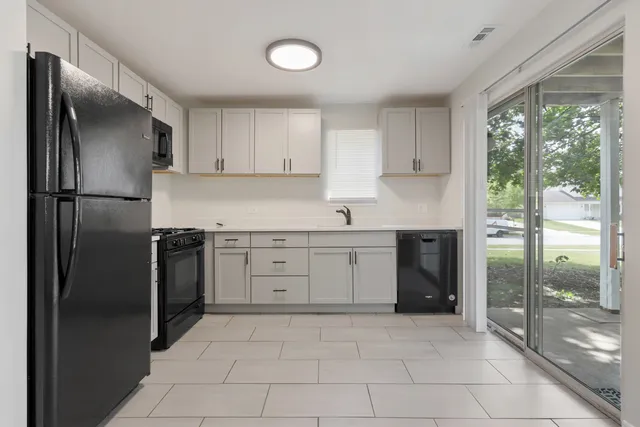 a kitchen with a refrigerator sink and cabinets