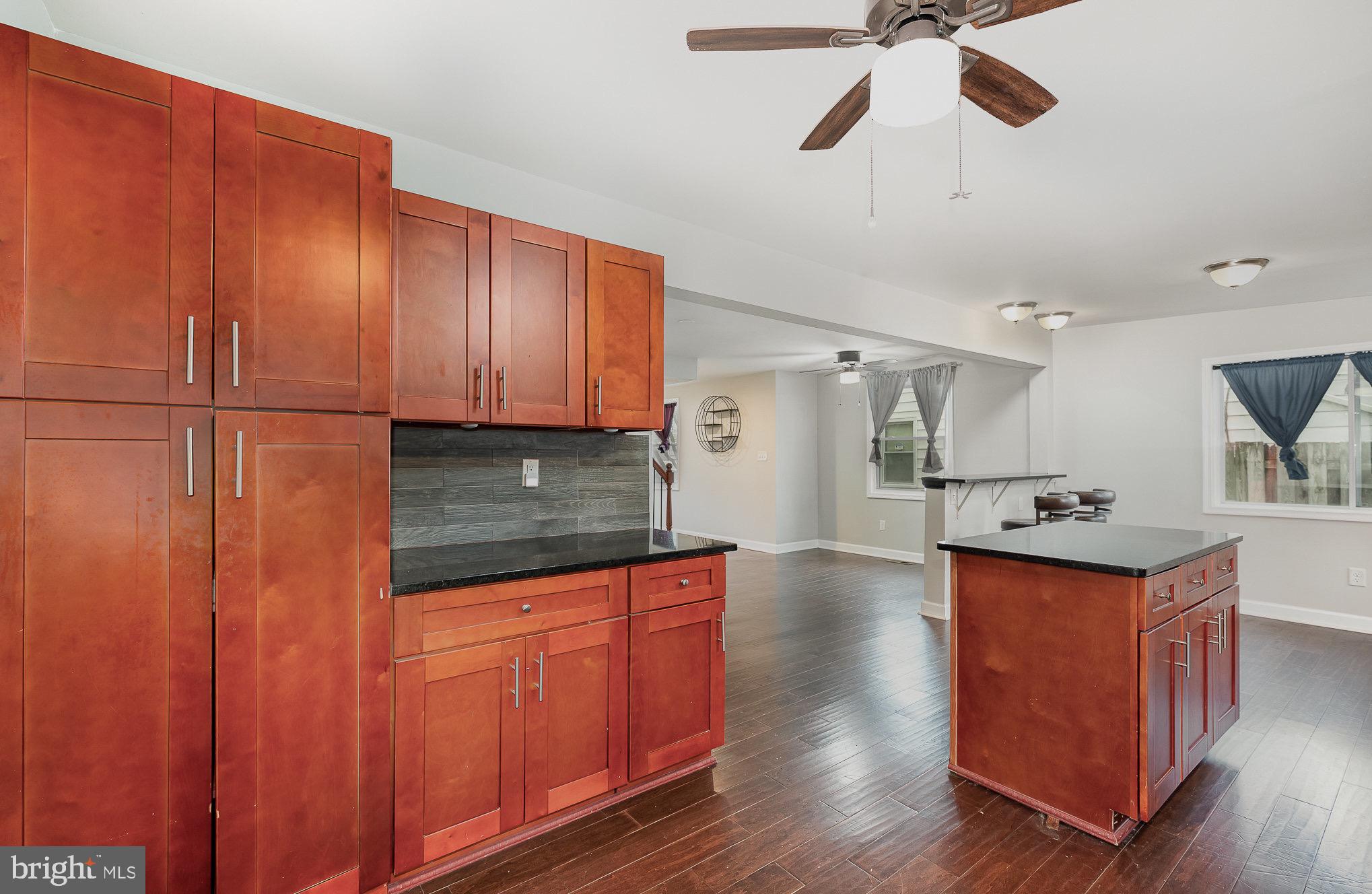 3402 Cornwall Road Dundalk, MD 21222 - Photo 11 of 25 a kitchen with stainless steel appliances granite countertop wooden cabinets a sink dishwasher a stove and a refrigerator with wooden floor