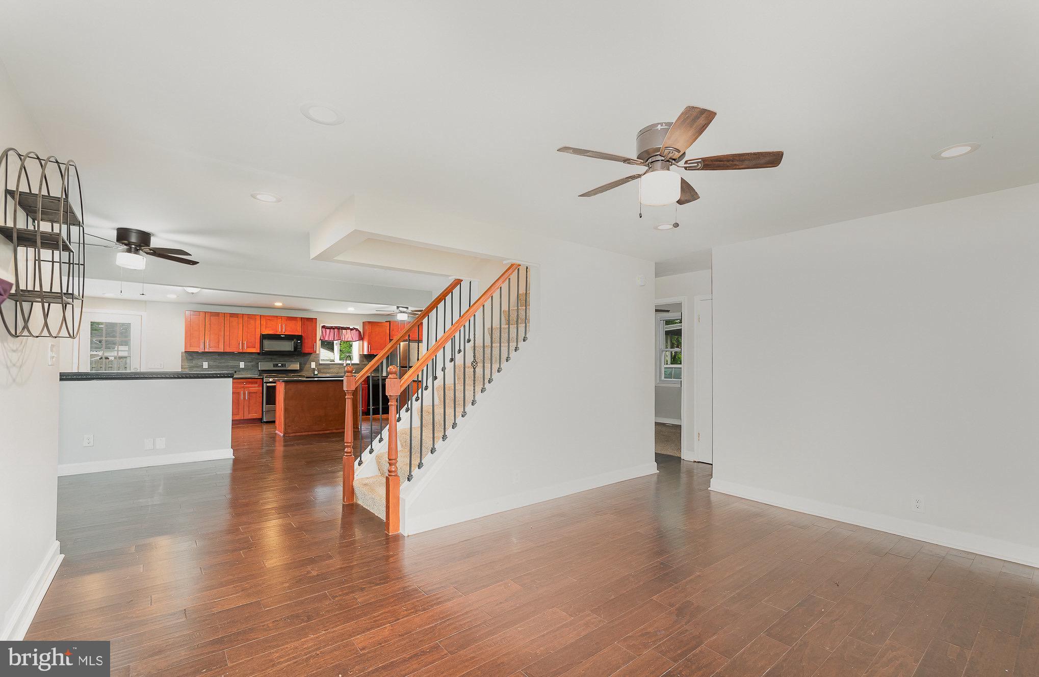 3402 Cornwall Road Dundalk, MD 21222 - Photo 6 of 25 a view of a room with wooden floor staircase and a kitchen