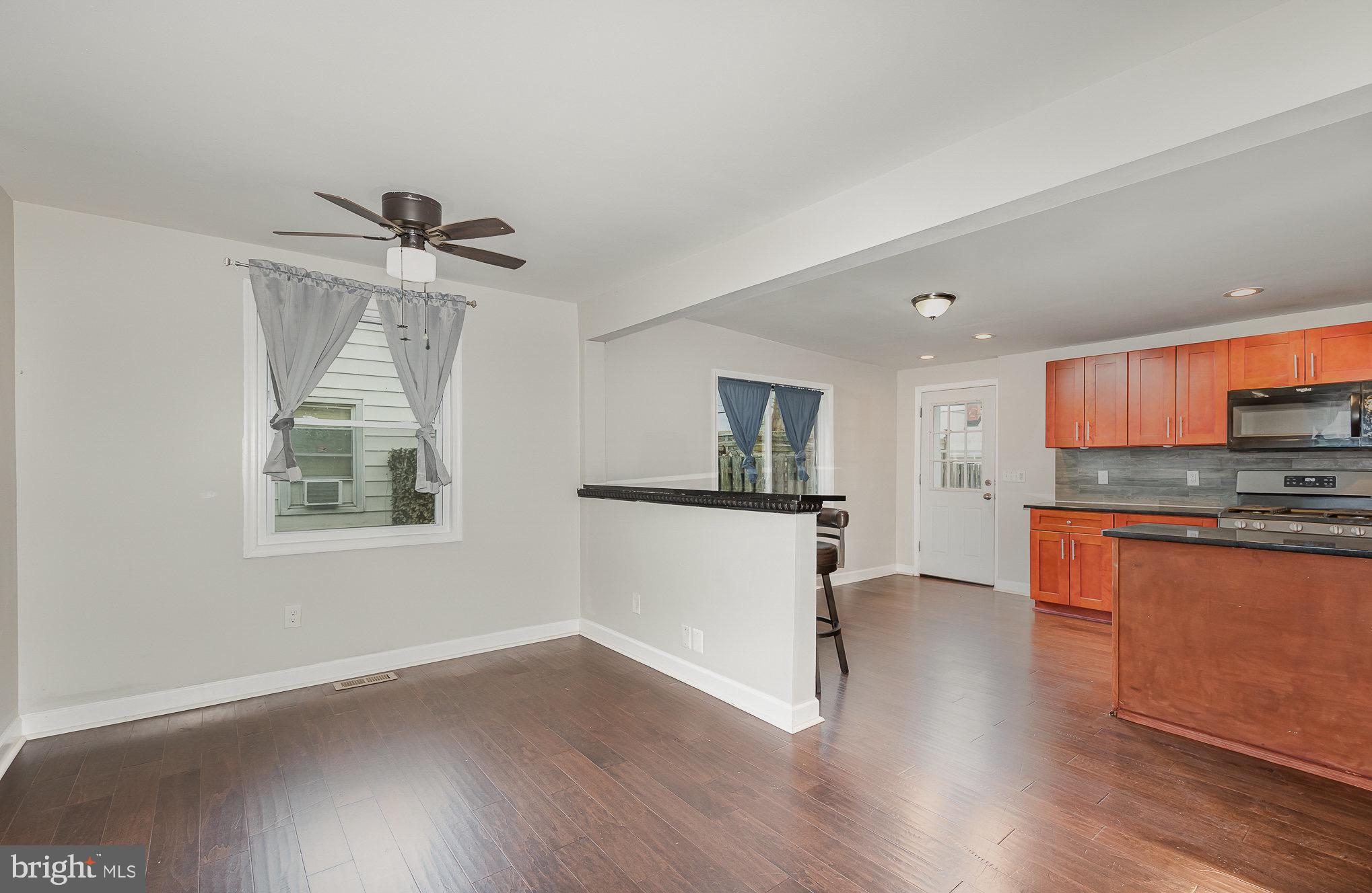 3402 Cornwall Road Dundalk, MD 21222 - Photo 7 of 25 a view of a kitchen with a sink wooden floor and a living room