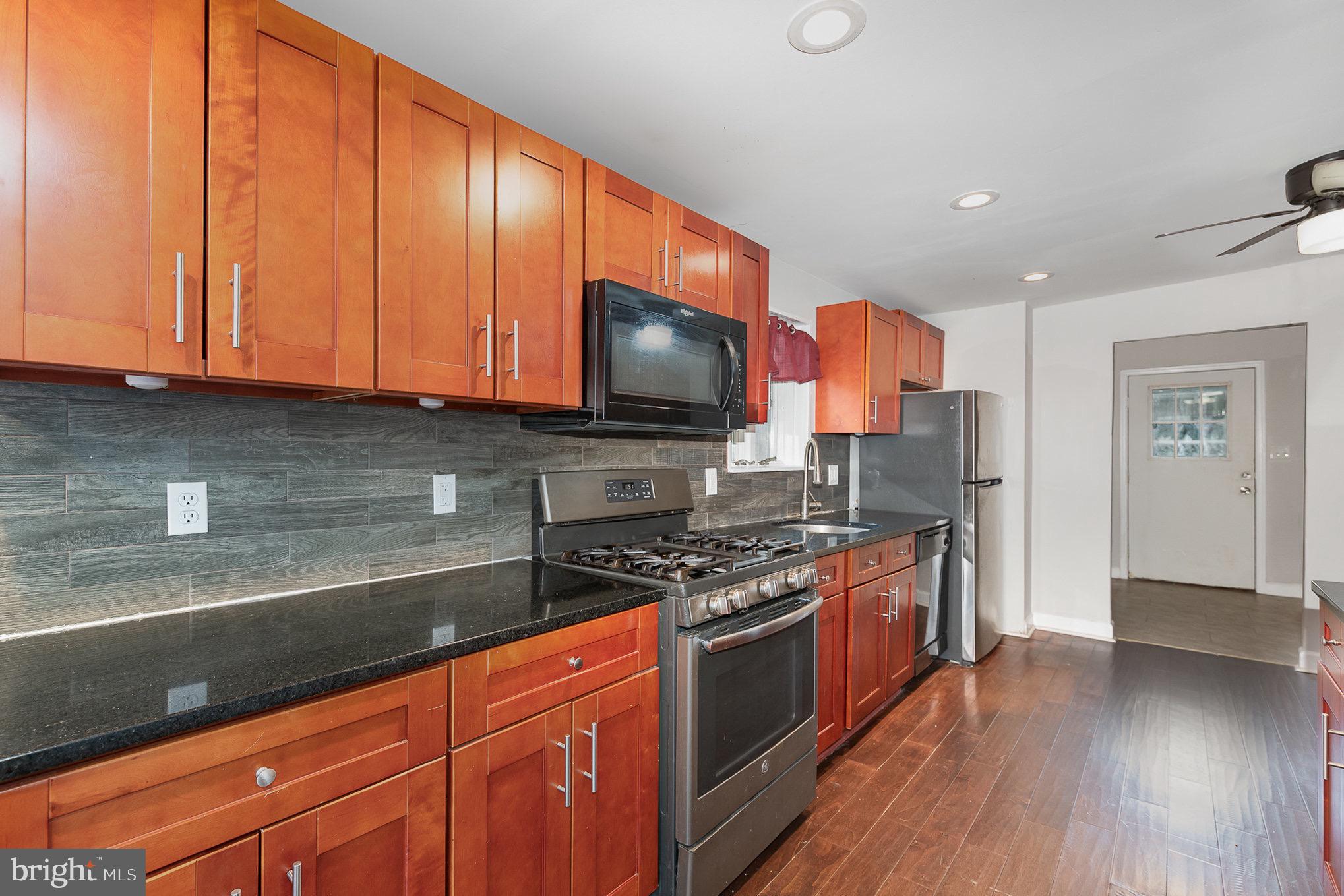 3402 Cornwall Road Dundalk, MD 21222 - Photo 9 of 25 a kitchen with stainless steel appliances granite countertop a stove a sink and a microwave