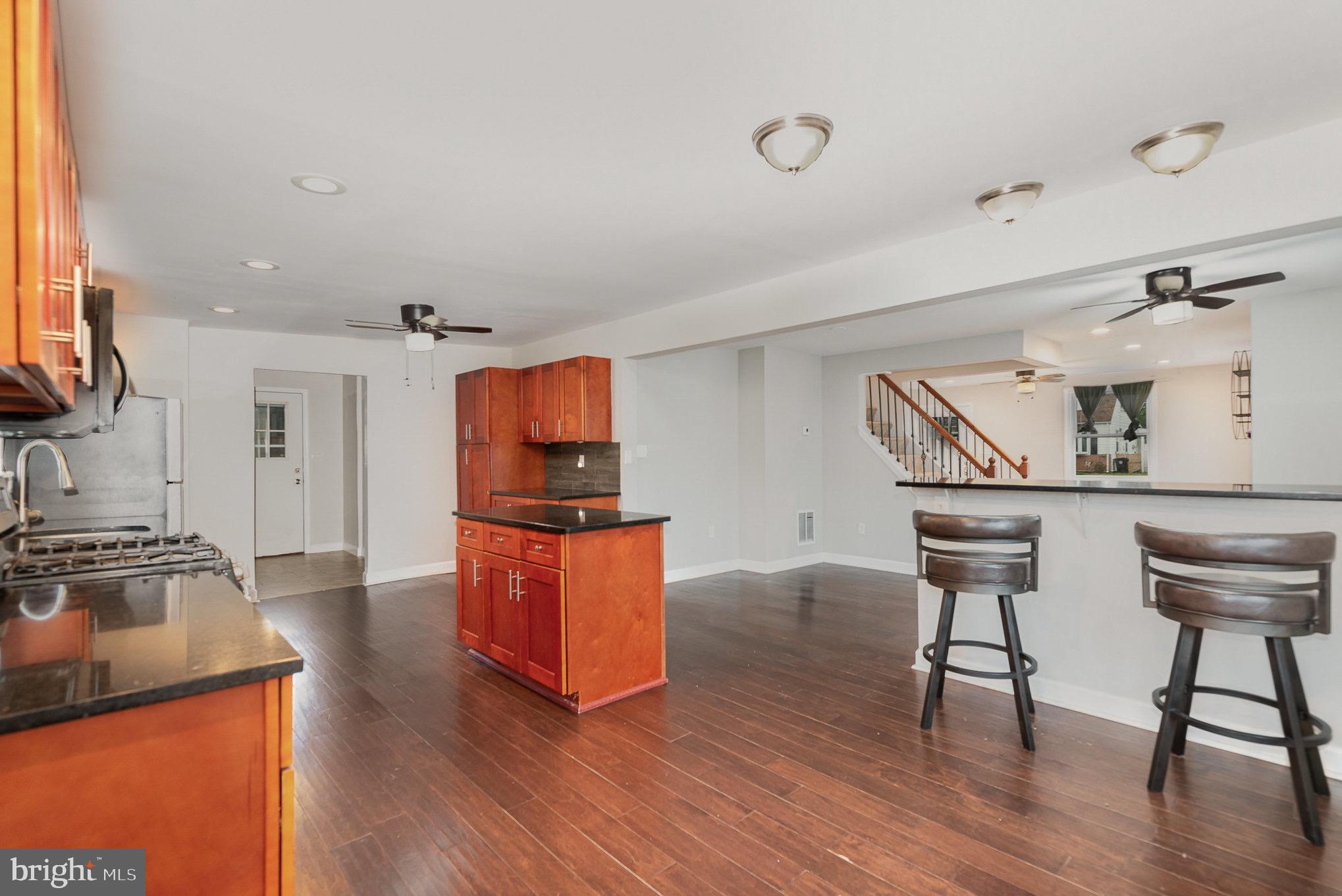 3402 Cornwall Road Dundalk, MD 21222 - Photo 10 of 25 a kitchen with stainless steel appliances granite countertop a sink a stove and a wooden floors