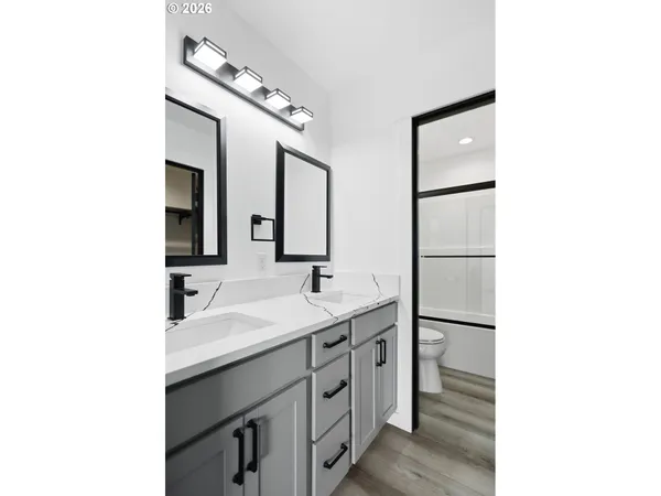 a bathroom with a double vanity sink a mirror and shower