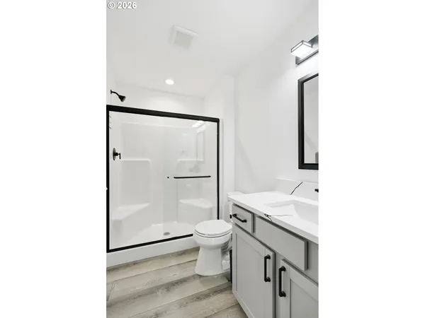 a bathroom with a sink a toilet a mirror and shower