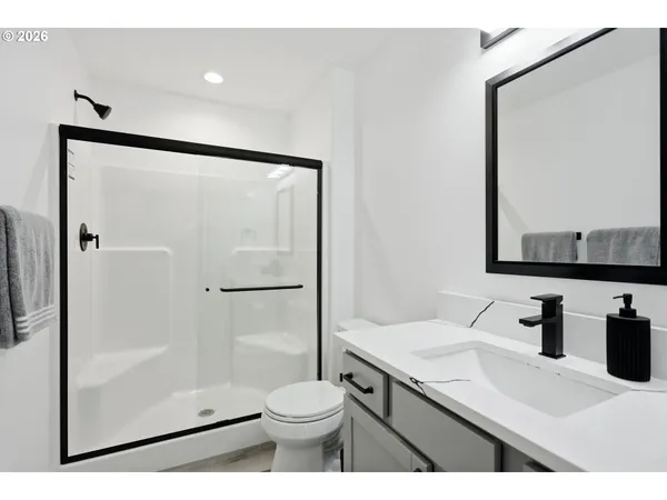 a bathroom with a sink a toilet and shower