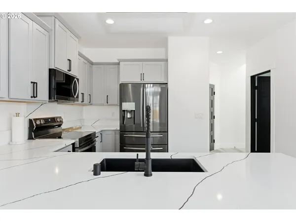 a bedroom with a bed a television and a refrigerator