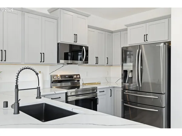 a kitchen with granite countertop a refrigerator and a sink