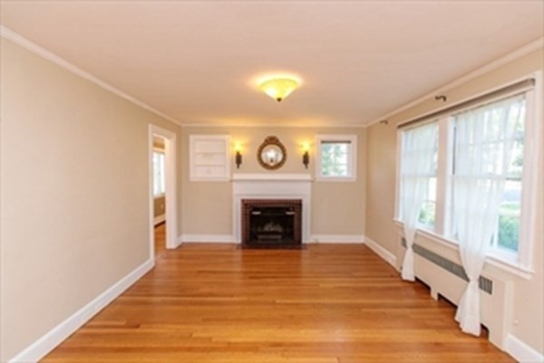 82 Beechwood Road Wellesley, MA 02482 - Photo 5 of 25 a view of an empty room with wooden floor fireplace and a window