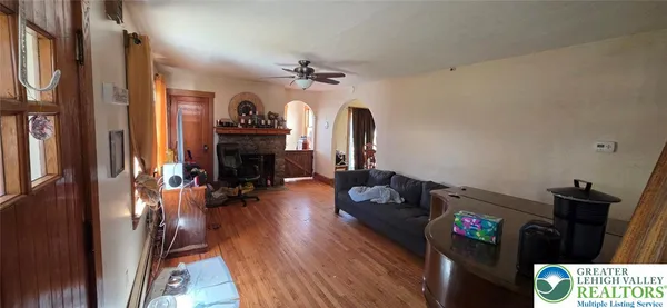 a view of a livingroom with furniture hardwood floor and a ceiling fan