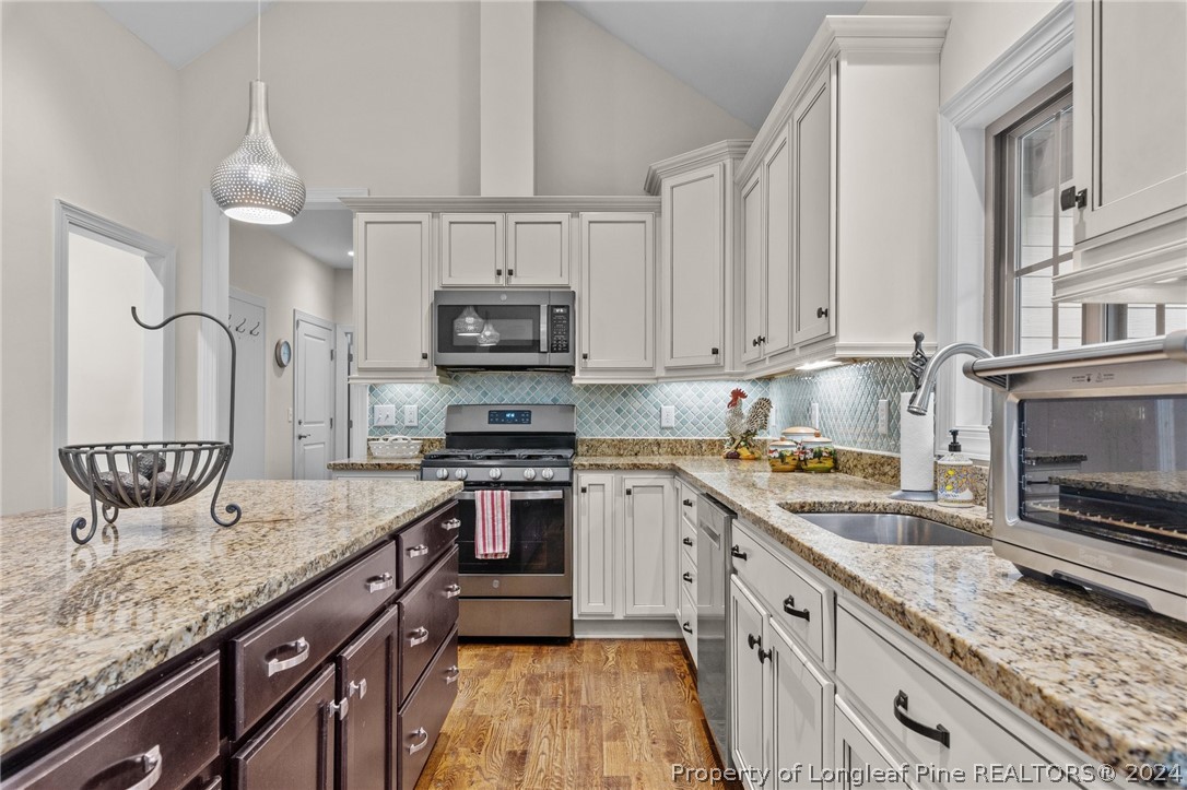 208 Rob Roy Road Southern Pines, NC 28387 - Photo 12 of 48 a kitchen with stainless steel appliances granite countertop a sink stove microwave and cabinets