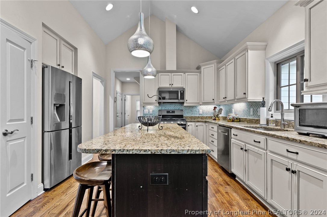 208 Rob Roy Road Southern Pines, NC 28387 - Photo 13 of 48 a kitchen with kitchen island granite countertop a refrigerator stove microwave and sink