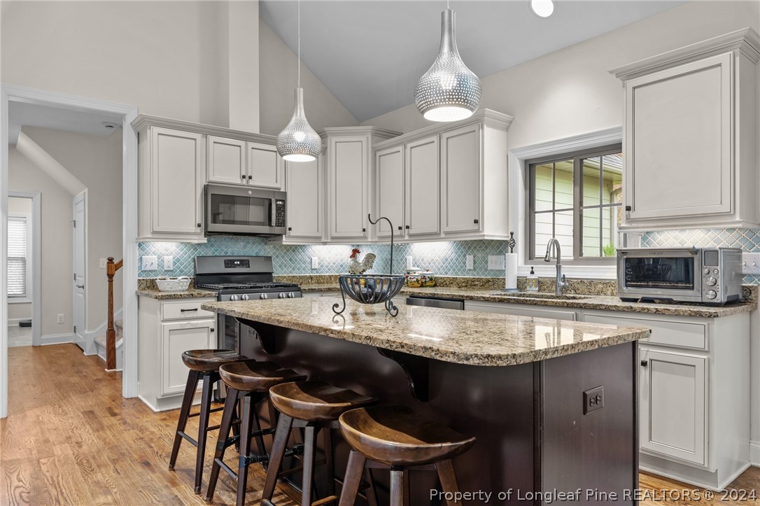208 Rob Roy Road Southern Pines, NC 28387 - Photo 15 of 48 a kitchen with kitchen island granite countertop a sink stove and microwave