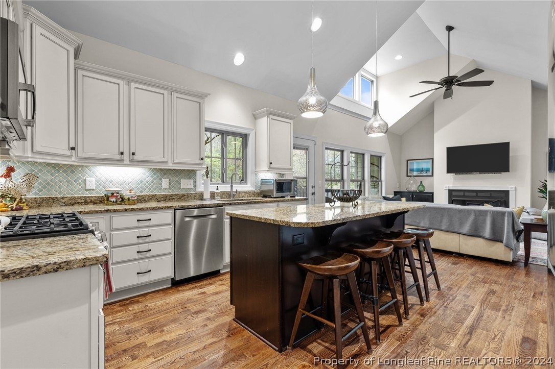 208 Rob Roy Road Southern Pines, NC 28387 - Photo 16 of 48 a kitchen with kitchen island granite countertop a sink counter top space appliances and cabinets