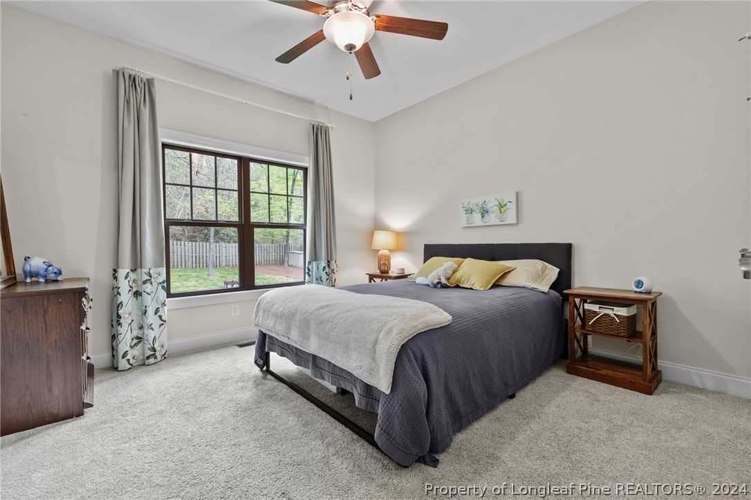 208 Rob Roy Road Southern Pines, NC 28387 - Photo 20 of 48 a spacious bedroom with a bed and a chandelier