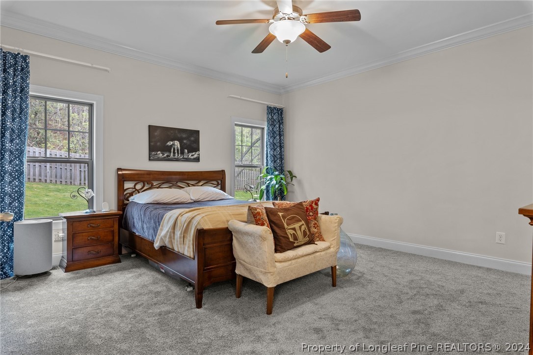 208 Rob Roy Road Southern Pines, NC 28387 - Photo 27 of 48 a bedroom with a bed and a chandelier