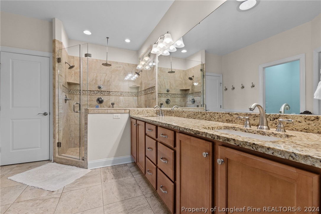 208 Rob Roy Road Southern Pines, NC 28387 - Photo 28 of 48 a bathroom with a granite countertop sink a large mirror and a shower