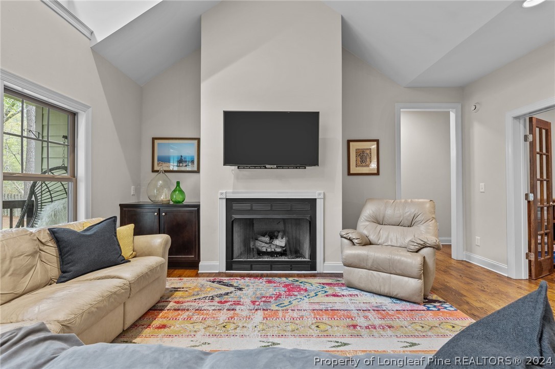 208 Rob Roy Road Southern Pines, NC 28387 - Photo 9 of 48 a living room with furniture a flat screen tv and a fireplace