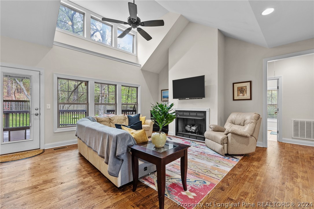 208 Rob Roy Road Southern Pines, NC 28387 - Photo 10 of 48 a living room with furniture a fireplace and a floor to ceiling window