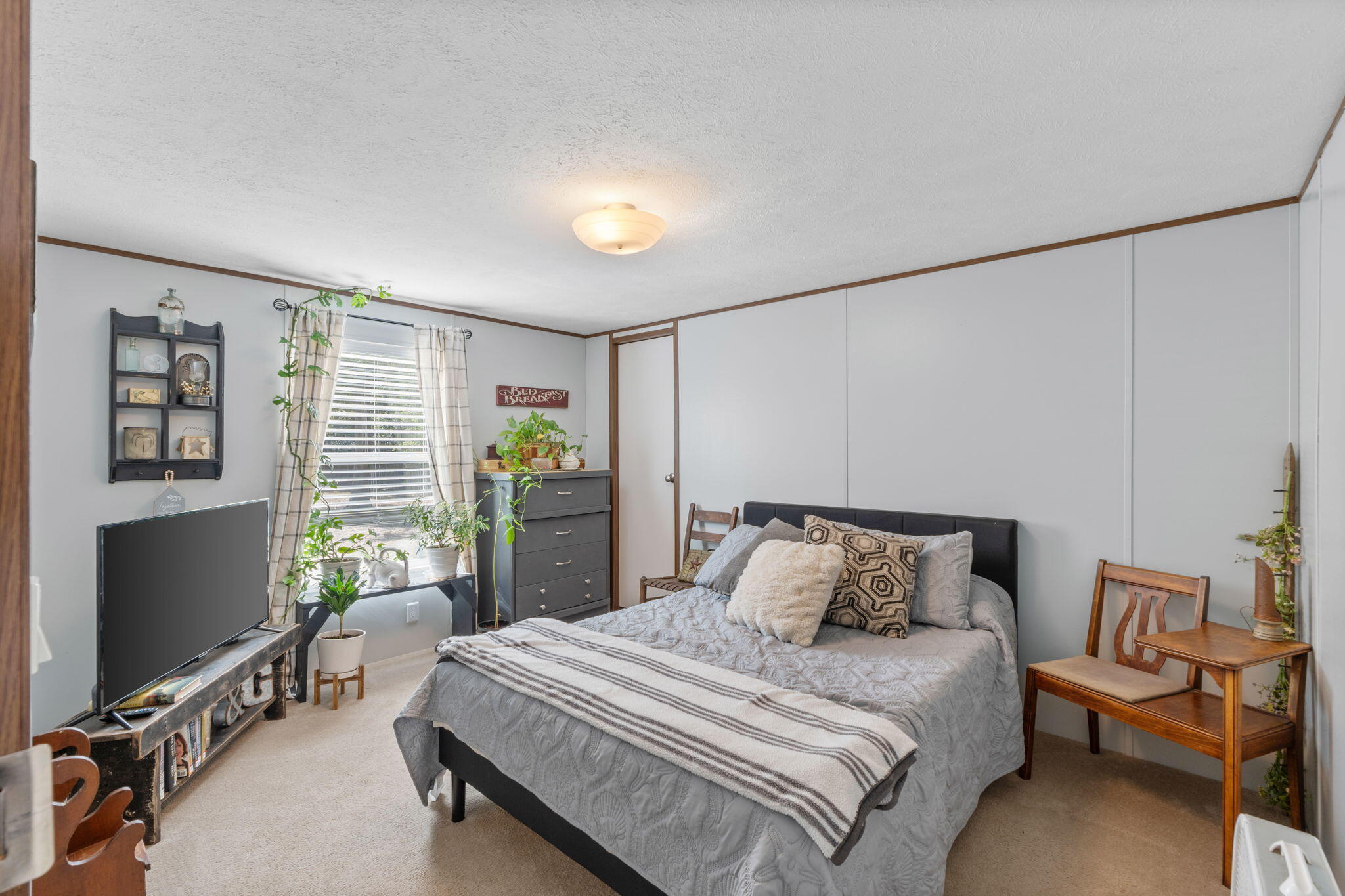 8680 John Hamm Road Milton, FL 32583 - Photo 24 of 44 a bedroom with a bed and a flat tv screen on dresser