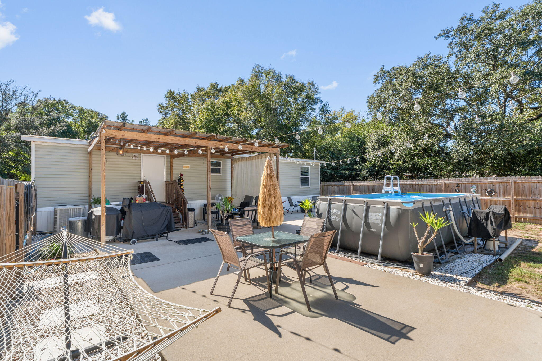 8680 John Hamm Road Milton, FL 32583 - Photo 27 of 44 a view of a patio with table and chairs with wooden floor and fence