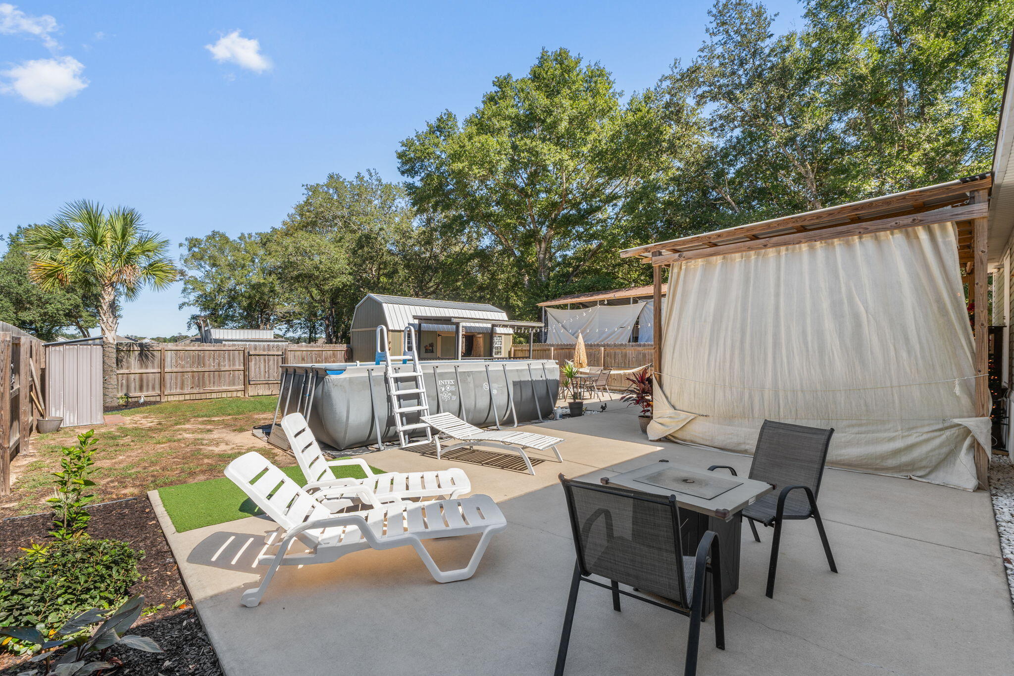 8680 John Hamm Road Milton, FL 32583 - Photo 28 of 44 a view of a patio with table and chairs with wooden fence and plants