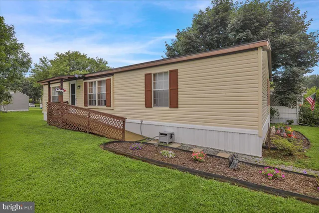 a view of a house with a backyard and a large tree