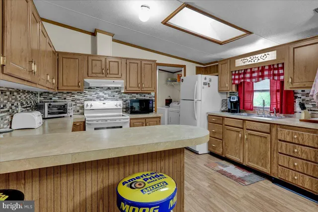 a kitchen with stainless steel appliances granite countertop a sink a stove and wooden cabinets