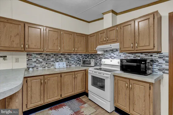 a kitchen with granite countertop a sink stove and cabinets