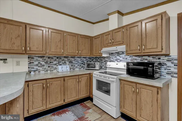 a kitchen with granite countertop a sink stove and cabinets