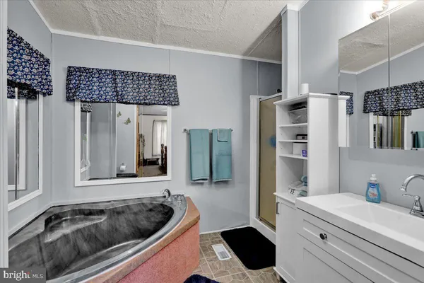 a bathroom with a granite countertop sink and a bathtub