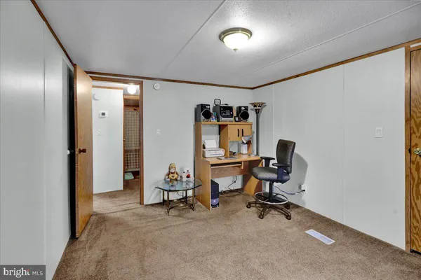 a view of a workspace with furniture and a window