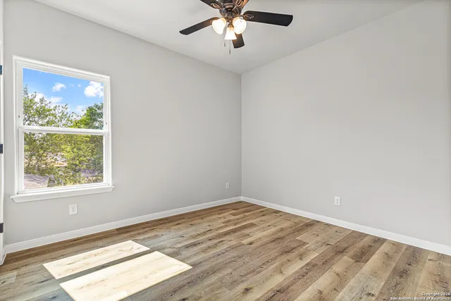 wooden floor in an empty room with a window