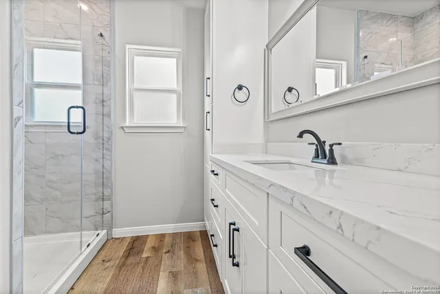a bathroom with a double vanity sink a mirror and a shower