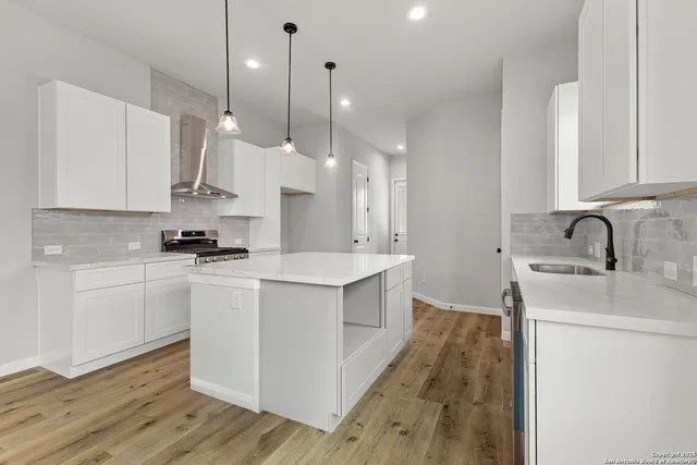 a open kitchen with kitchen island a sink stainless steel appliances and cabinets