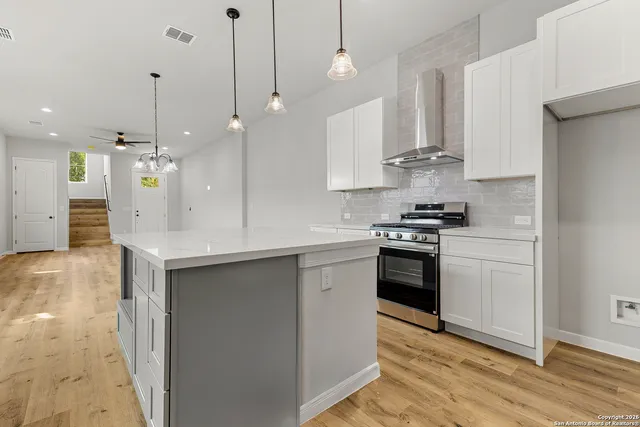 a kitchen with stainless steel appliances kitchen island granite countertop a stove a sink and a refrigerator