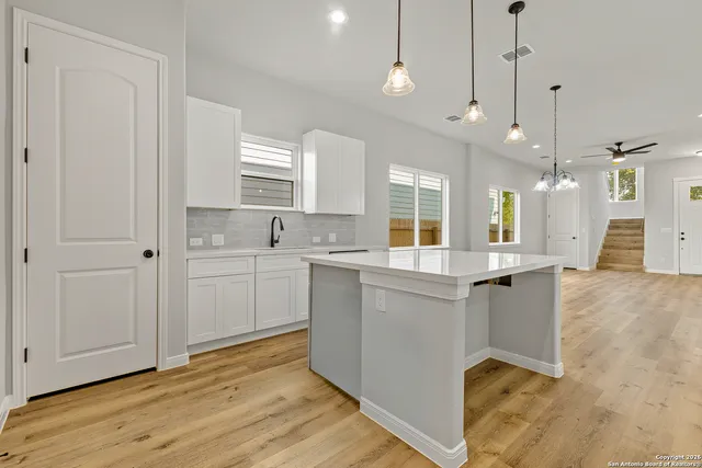 a large kitchen with cabinets and wooden floor