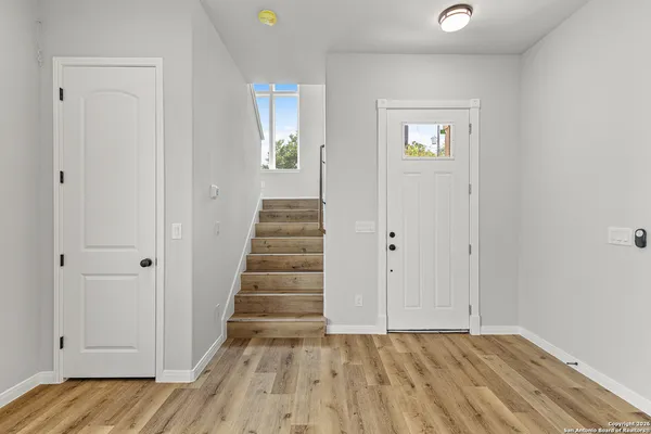 a view of a hallway with wooden floor and closet area